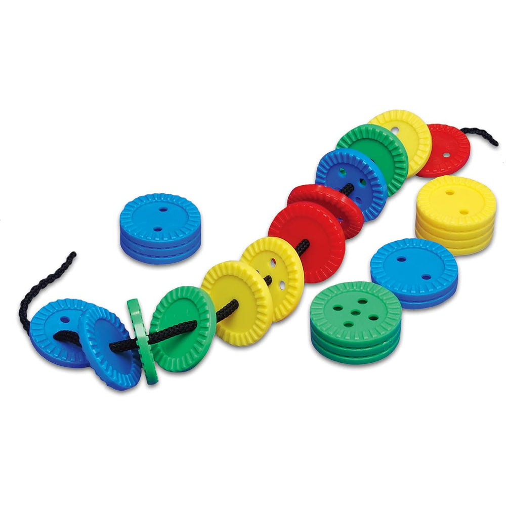 Colourful plastic Galt Fun Buttons threaded onto a black lace on a white background