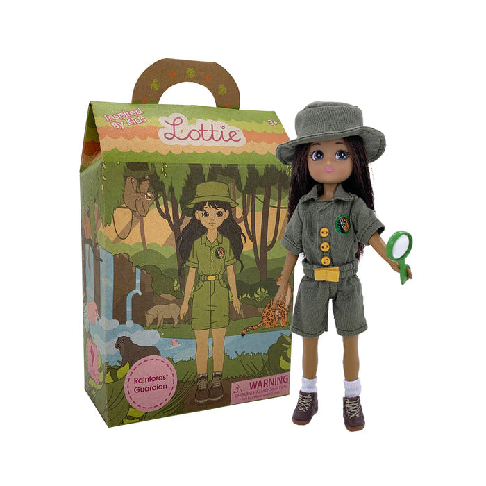 Toy Lottie doll in explorer outfit with hat, shorts, and shirt on a white background beside the box she comes in