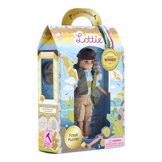The box for the Fossil Hunter Lottie Doll, in a dinosaur themed box with a see-through window showing the Lottie Doll wearing a gilet and shorts